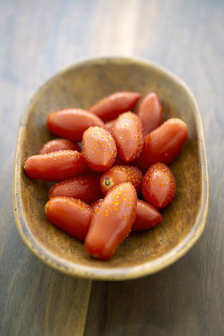 Freshly Washed Plum Tomatoes in a Wooden Bowl
