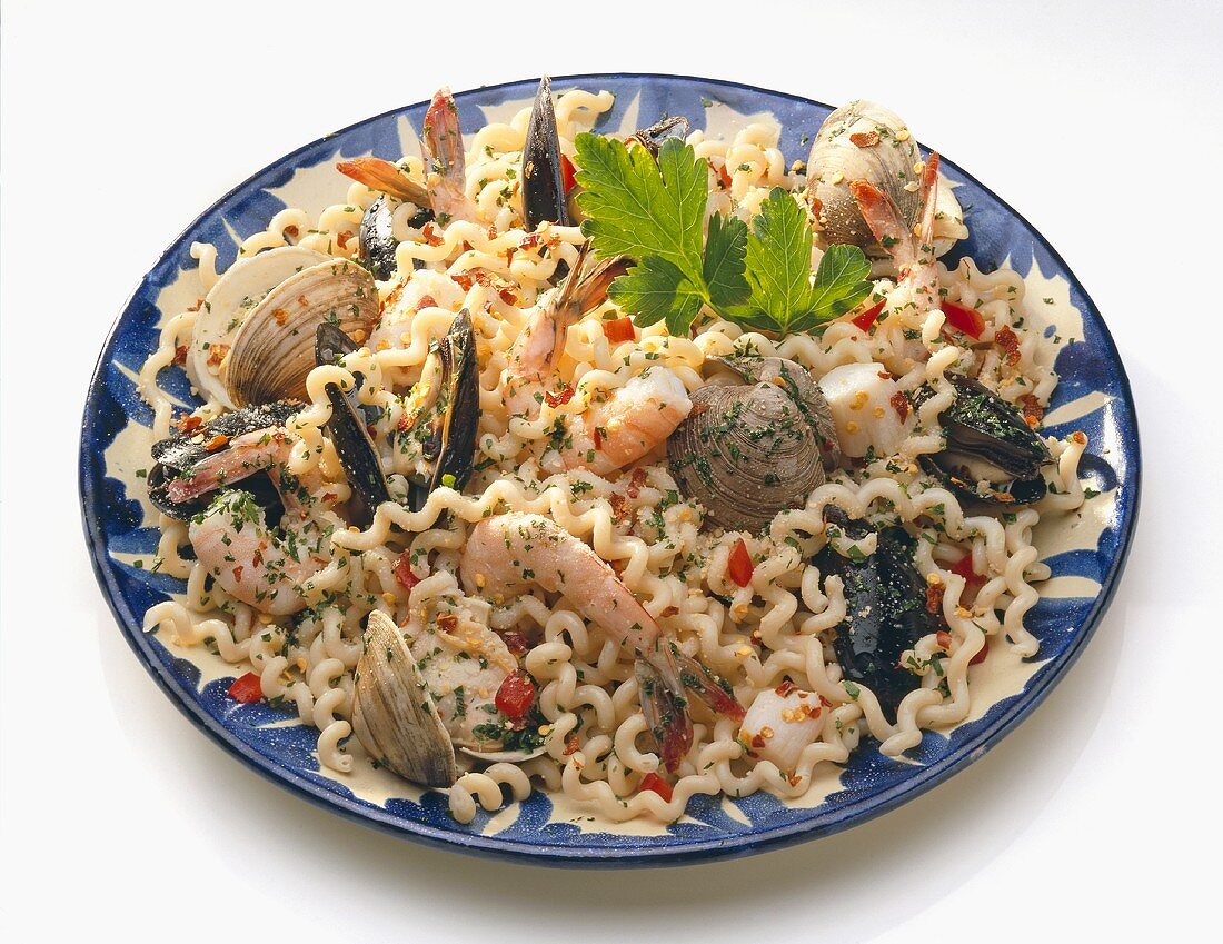 Large Plate of Pasta with Assorted Shellfish on a White Background