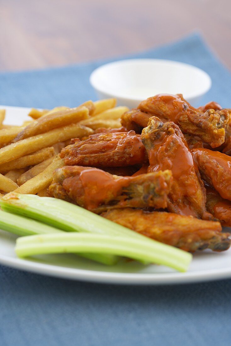 Buffalo Chicken Wings mit Selleriesticks und Pommes Frites