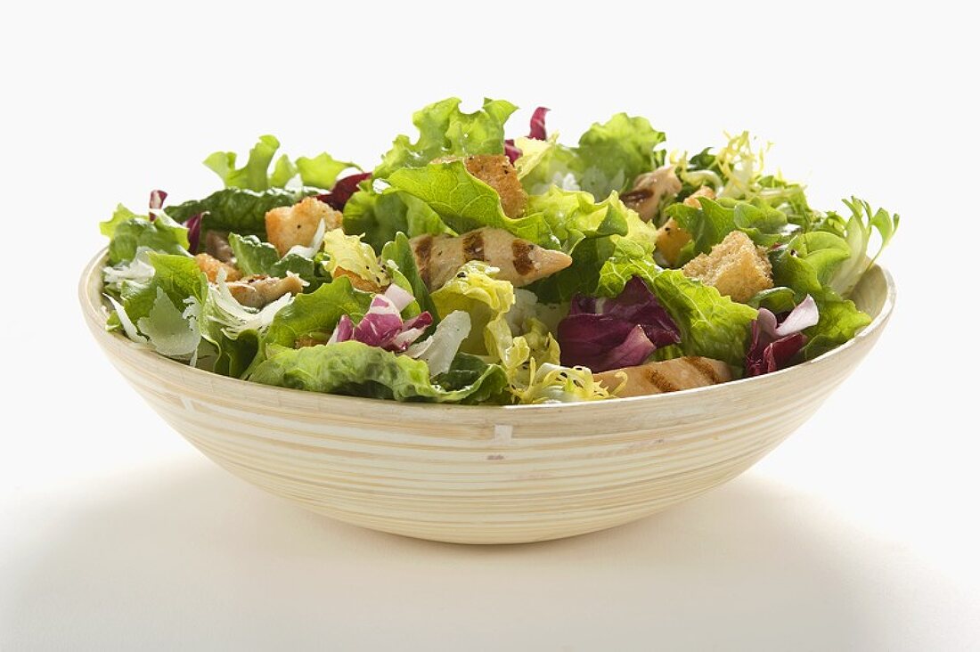 Grilled Chicken Salad with Mesclun Greens in a Bowl, White Background