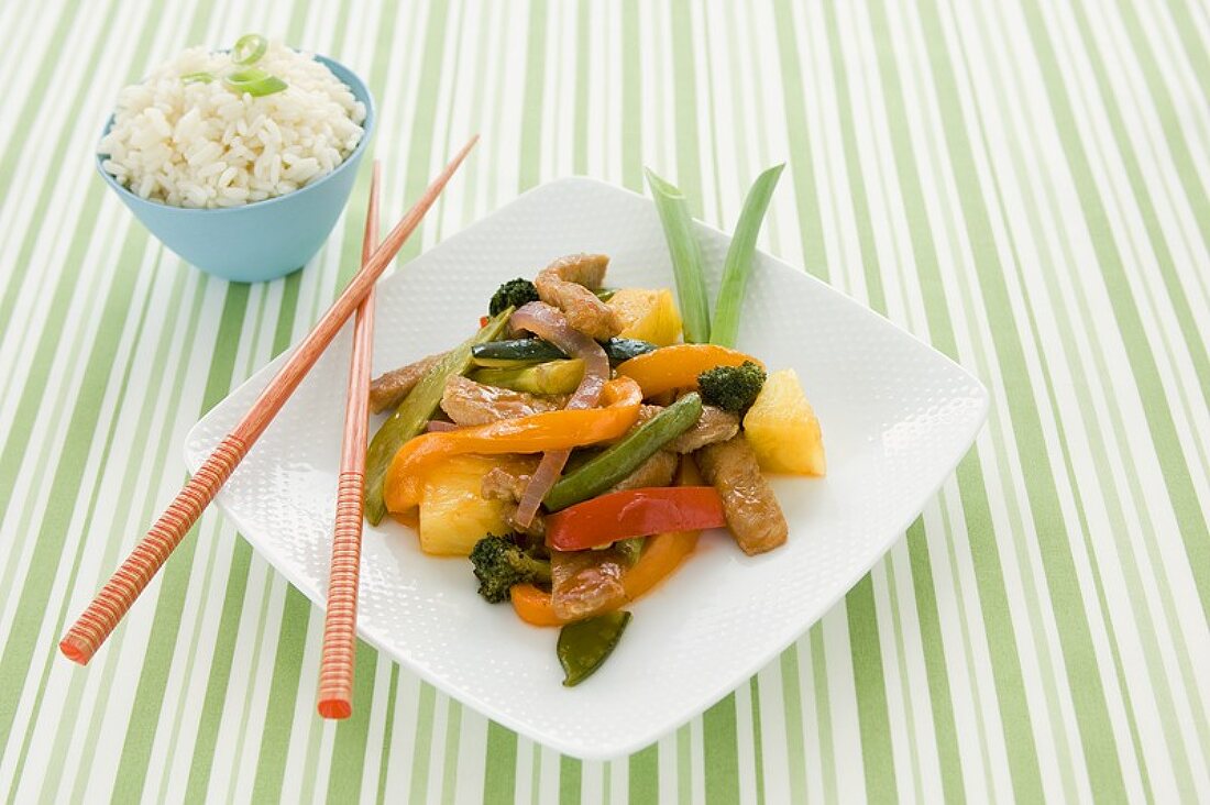 Sweet and Sour Pork with Vegetables, Chopsticks and a Bowl of Rice
