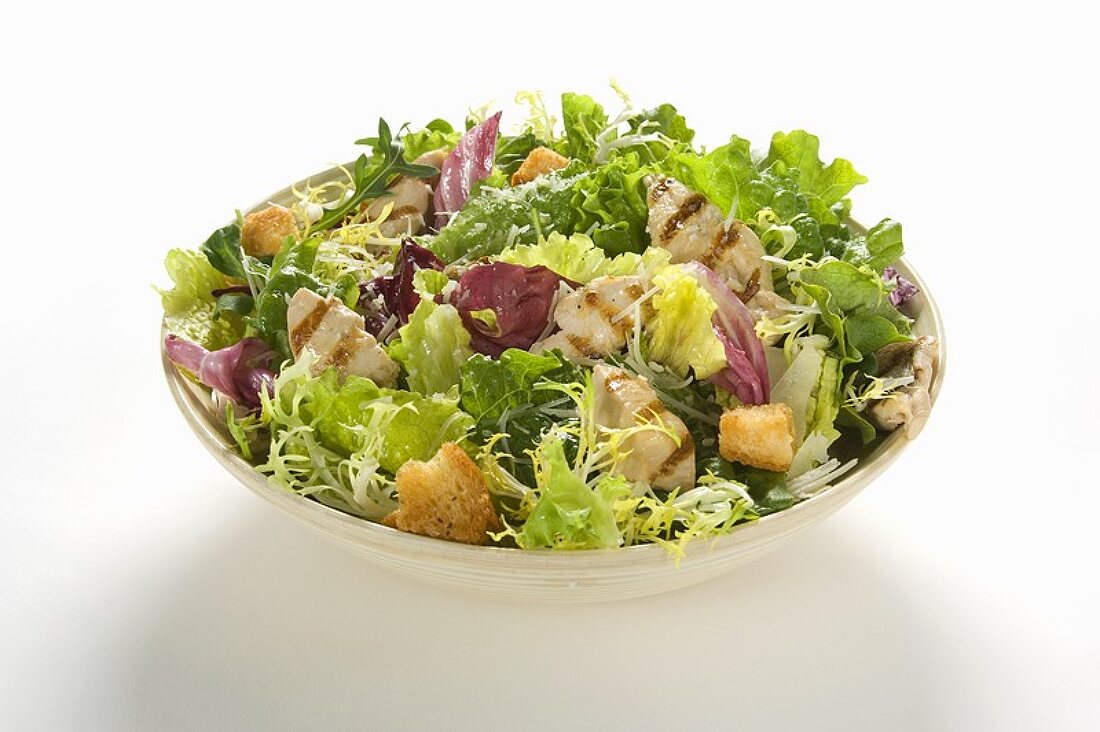 Bowl of Grilled Chicken Caesar Salad with Mixed Greens, White Background