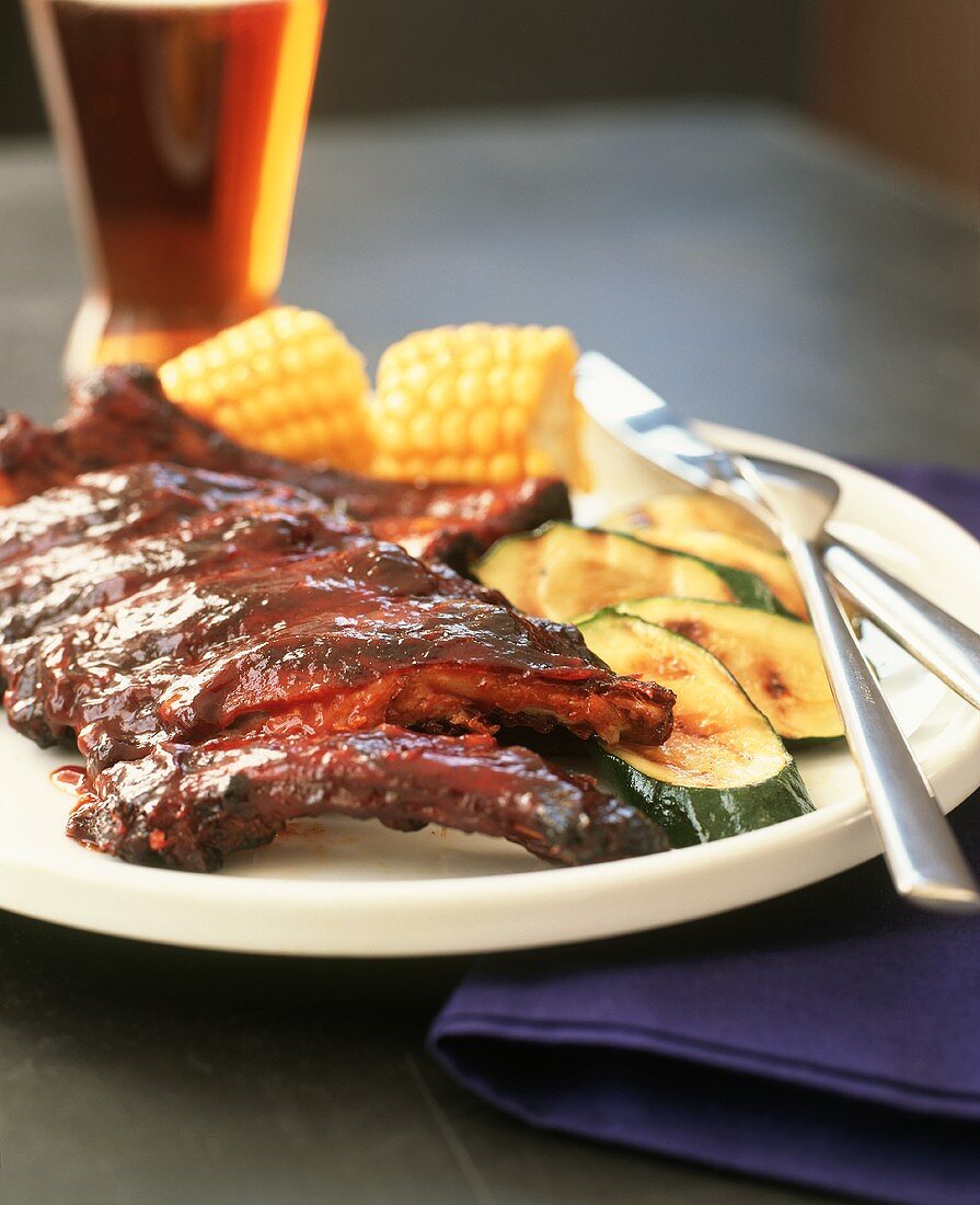 Barbecue Ribs on a Plate with Zucchini and Corn on the Cob; Beer