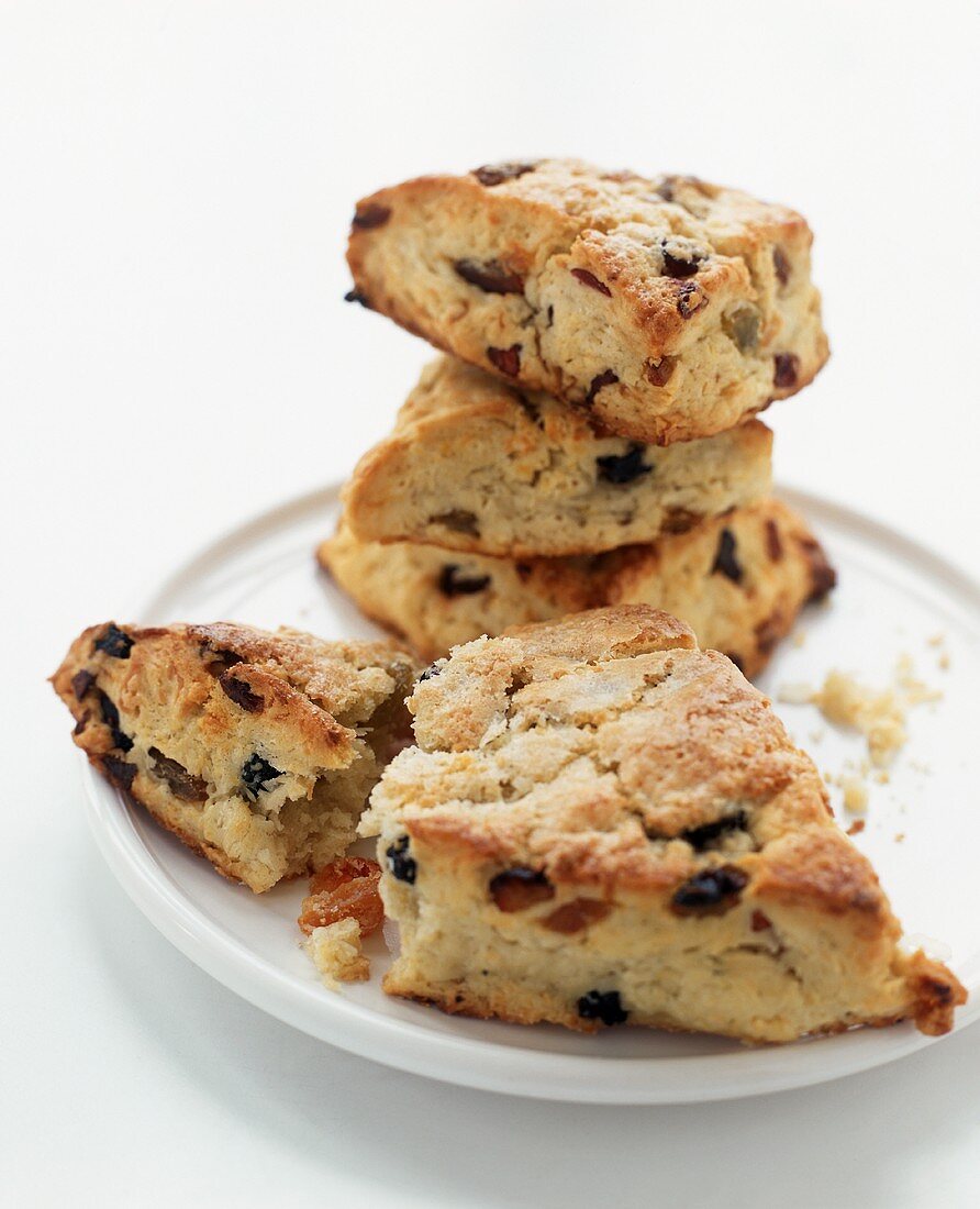 Scones with Dried Fruit on a Plate; Three Stacked; One Broken
