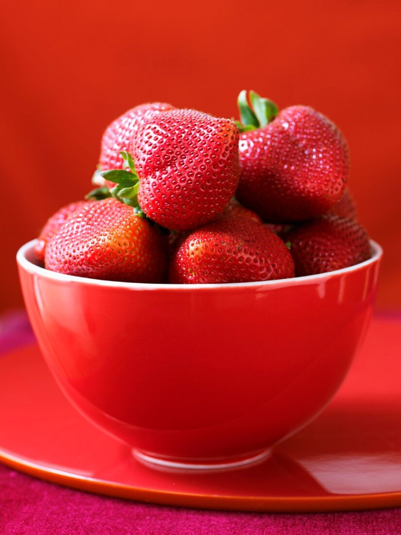 Fresh strawberries in a red bowl