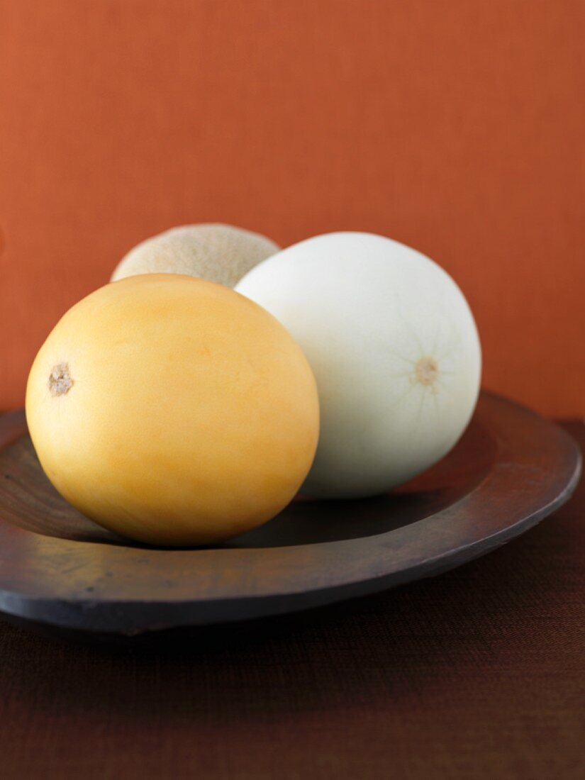 Three melons in a wooden dish