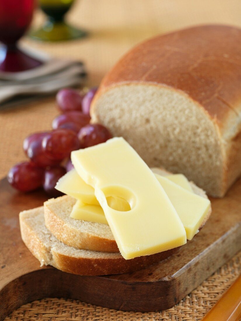 A few slices of semi-hard cheese, white bread and grapes