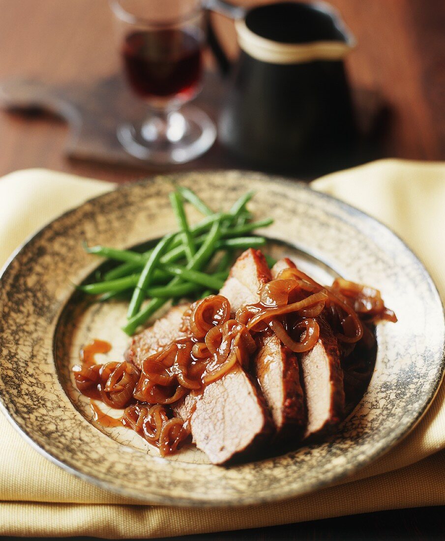 Sliced pork roast with caramelised onions