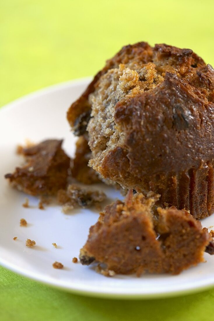 A Bran and Raisin Muffin with Piece Broken Off