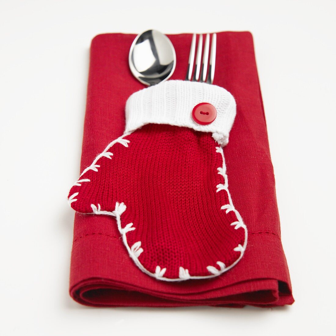 Roter Handschuh mit Silberbesteck auf roter Serviette