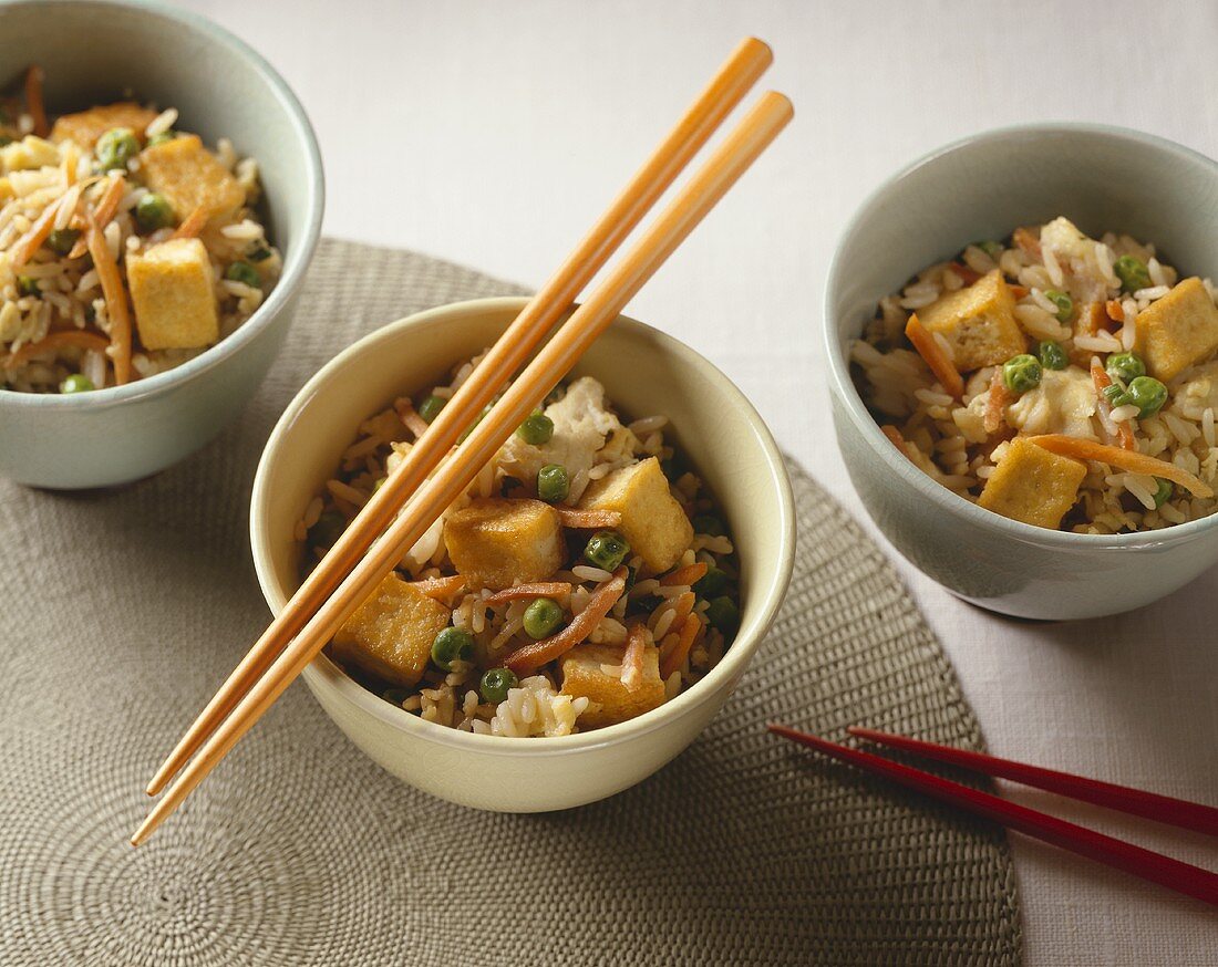 Three Bowls of Fried Rice with Tofu; Chopsticks