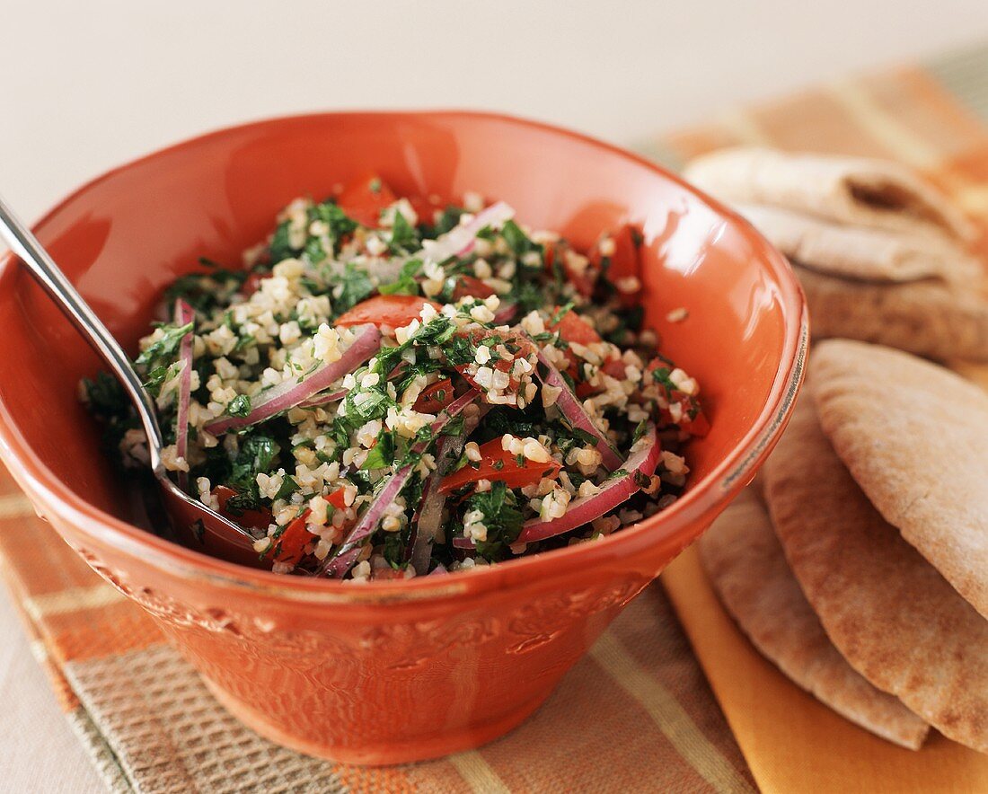Tabbouleh in a Bowl with Spoon; Pita Bread