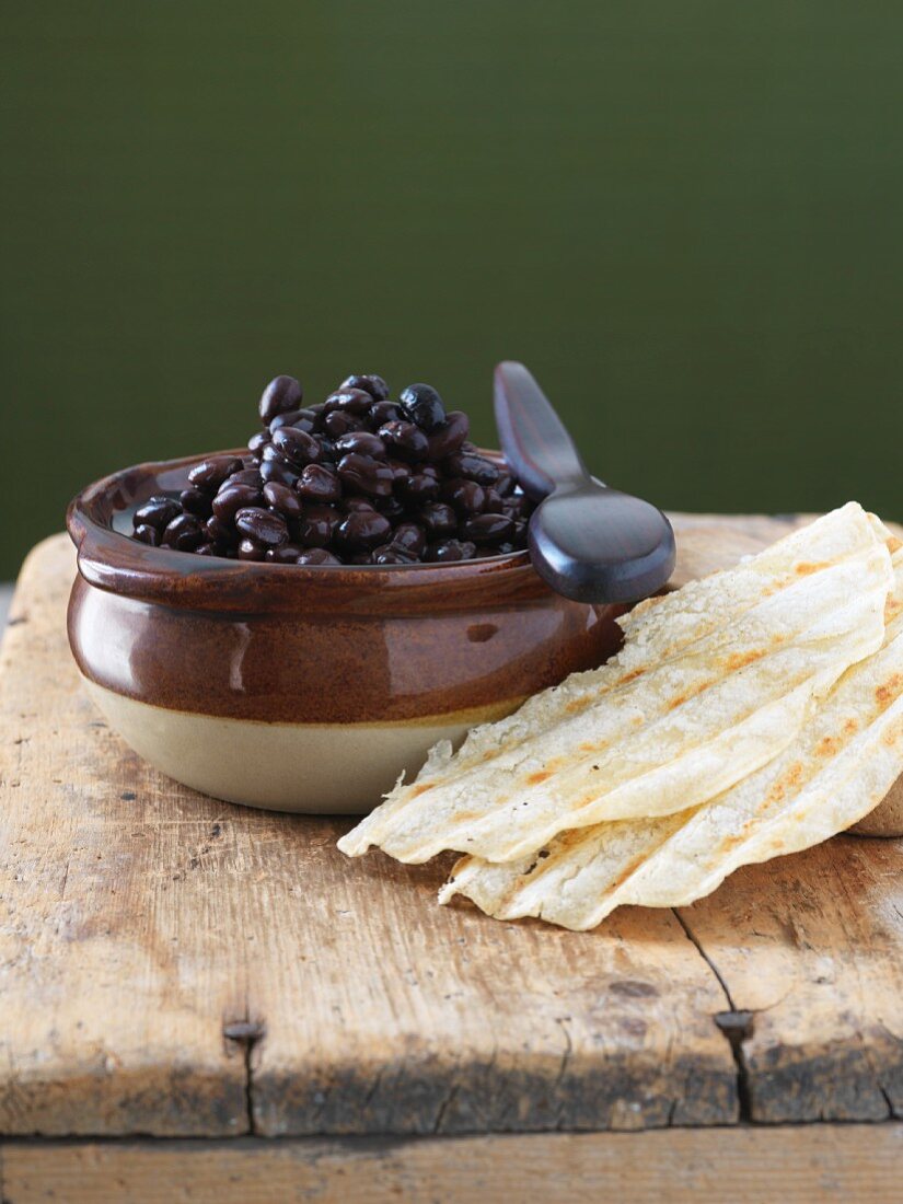 Schwarze Bohnen in einer Schale mit Tortilla