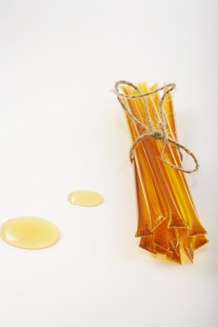 Bundle of Honey Sticks with Two Drips of Honey on White
