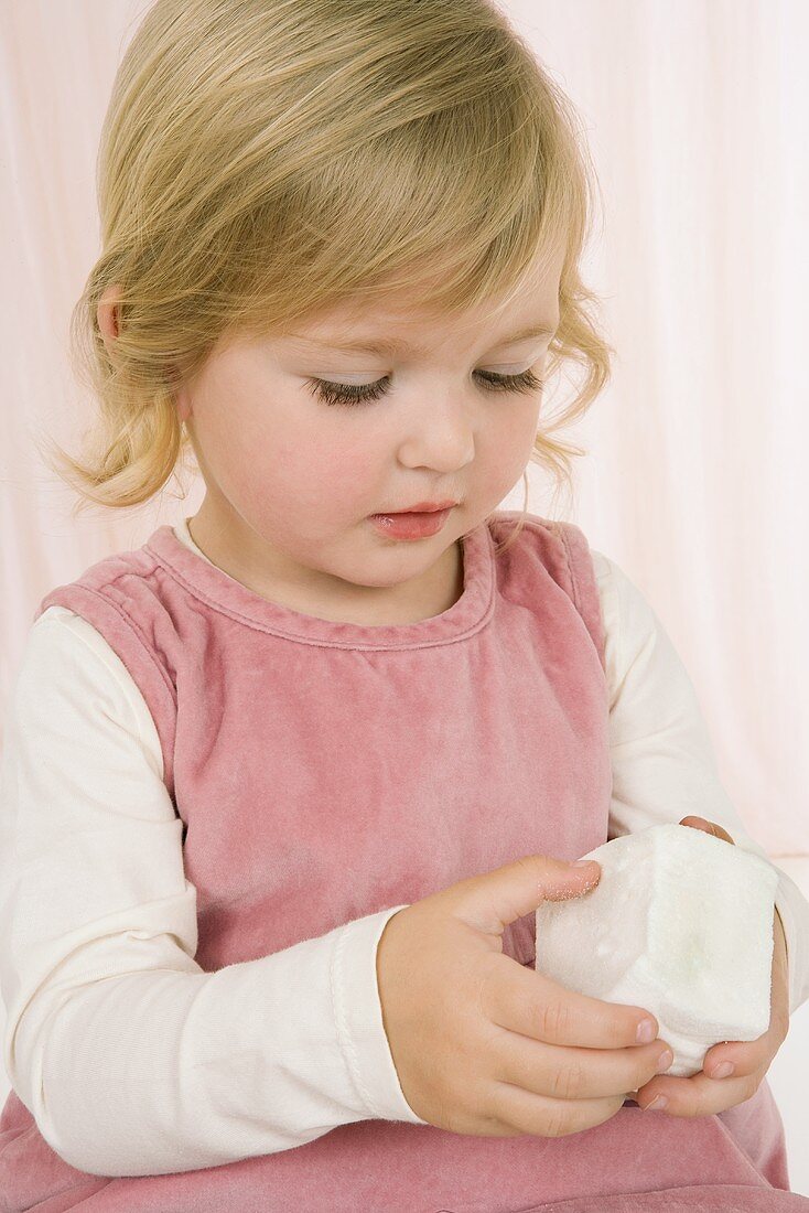 Kleines Mädchen hält grossen Marshmallow-Würfel