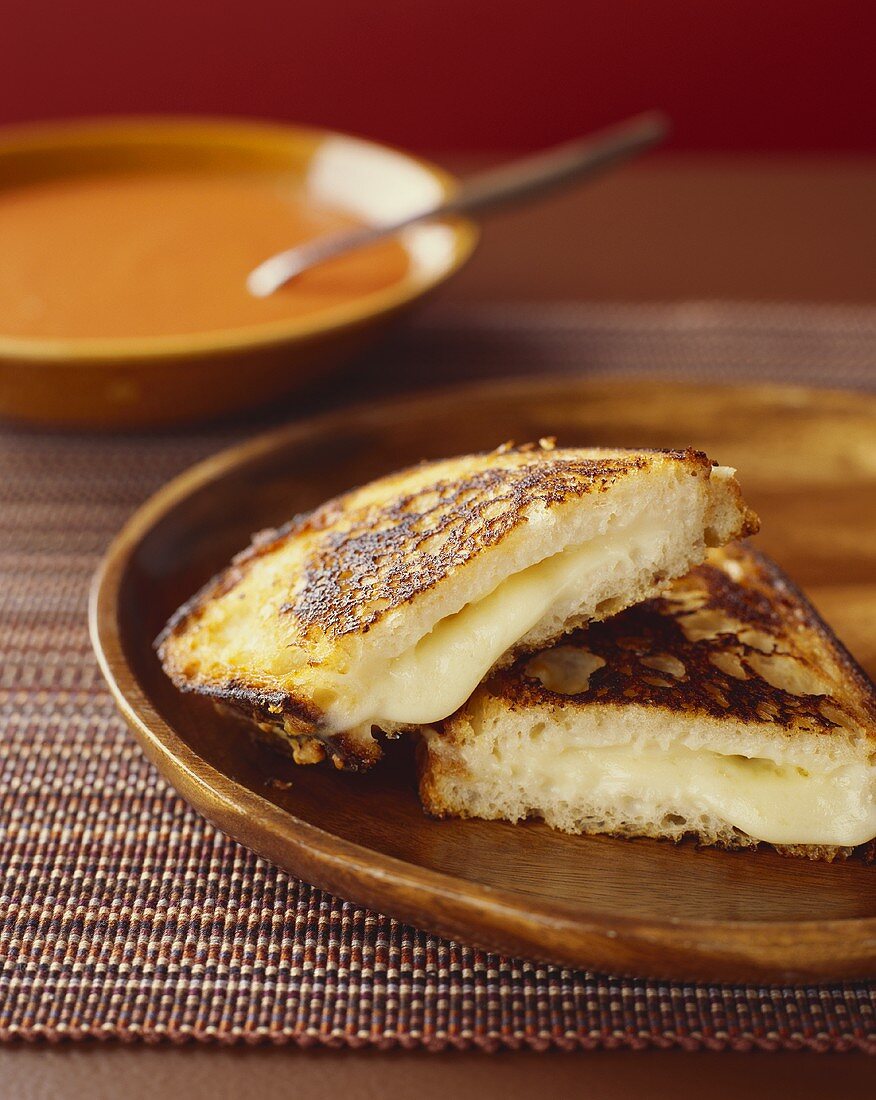 Ein halbiertes Käsesandwich mit Tomatensuppe