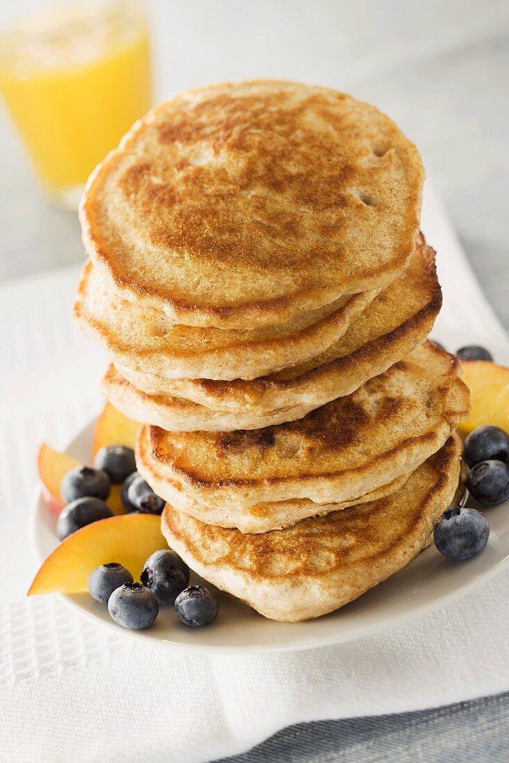 Tall Stack of Pancakes with Fresh Blueberries and Peachs