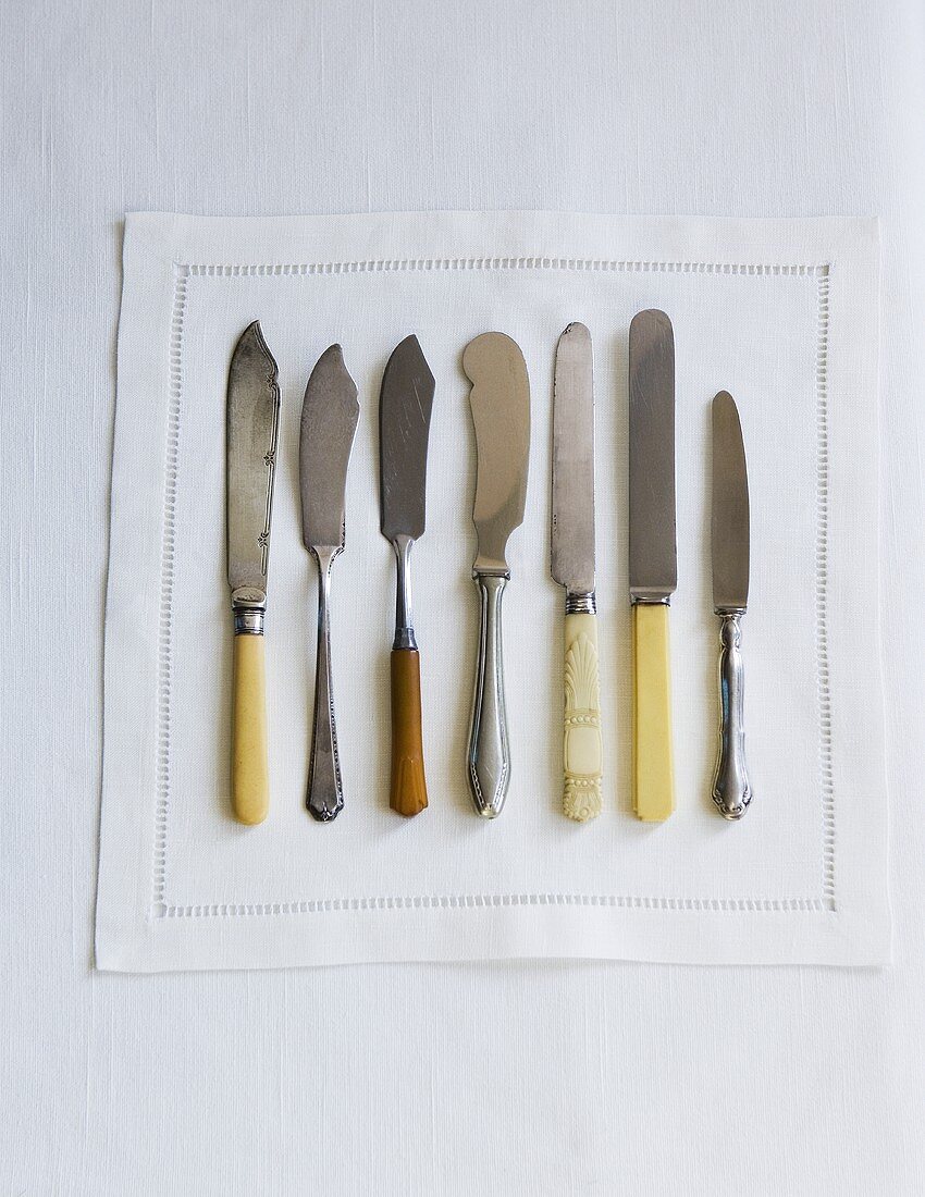 Variety of Knives on a White Napkin