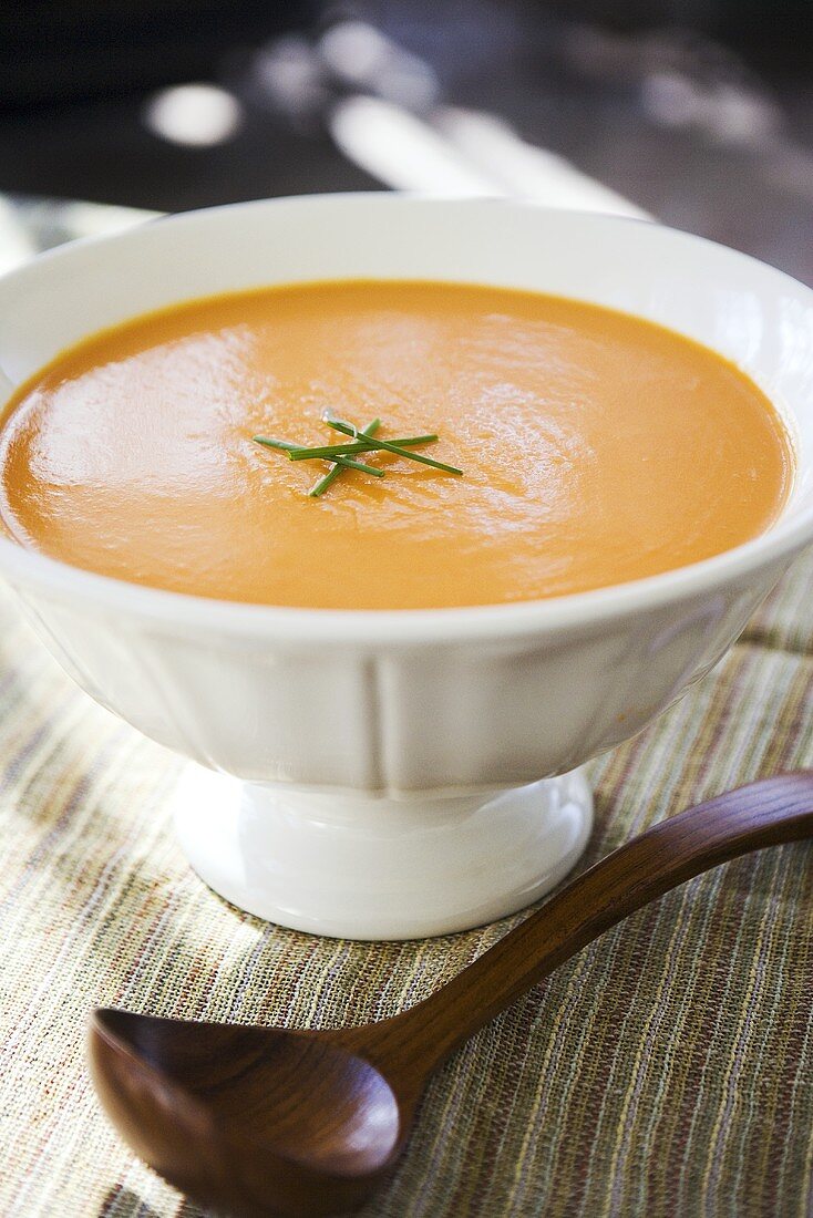 Tomatencremesuppe in einer Suppenschale mit Schöpflöffel