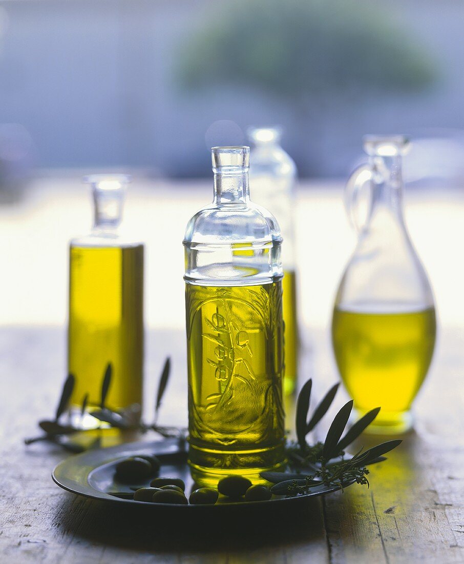 Olivenöl in Flaschen, Oliven und Olivenzweig