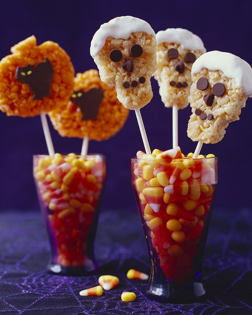 Reis-Kekse am Stiel in Gläsern mit Candy Corn zu Halloween