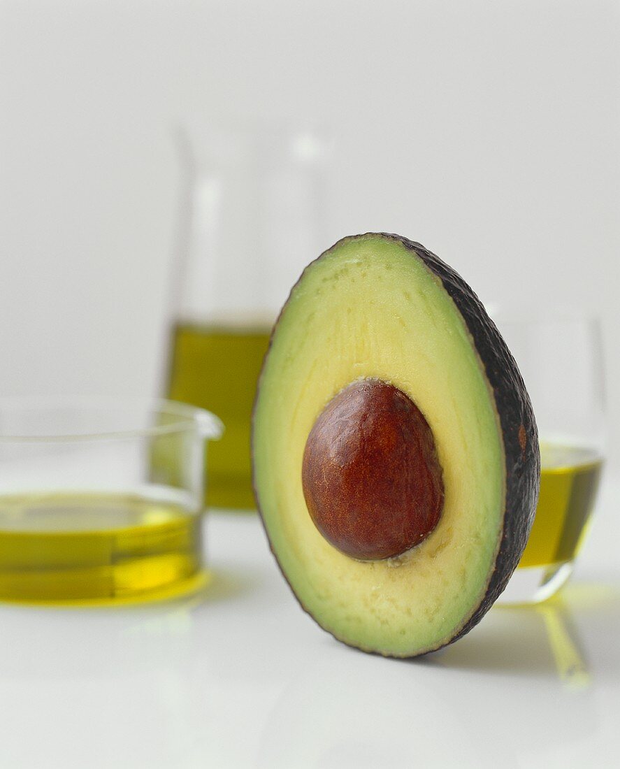 Eine halbe Avocado mit Stein und Olivenöl