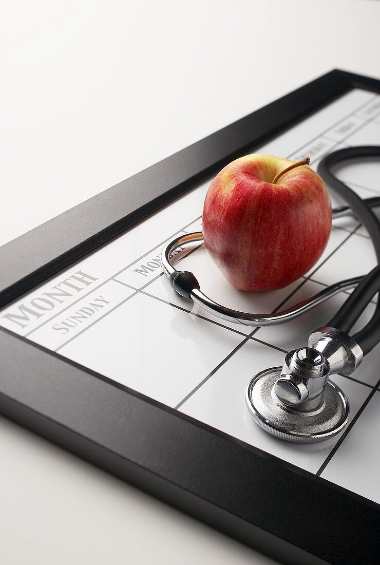 Kalender mit Apfel und Stethoskop