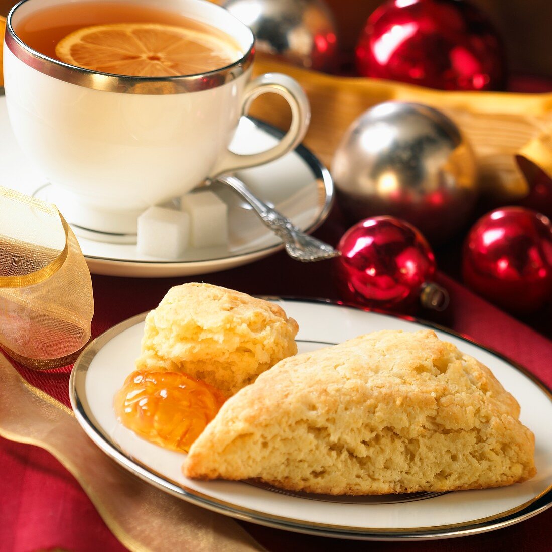 Scone mit Orangenmarmelade, Teetasse und Weihnachtsdeko