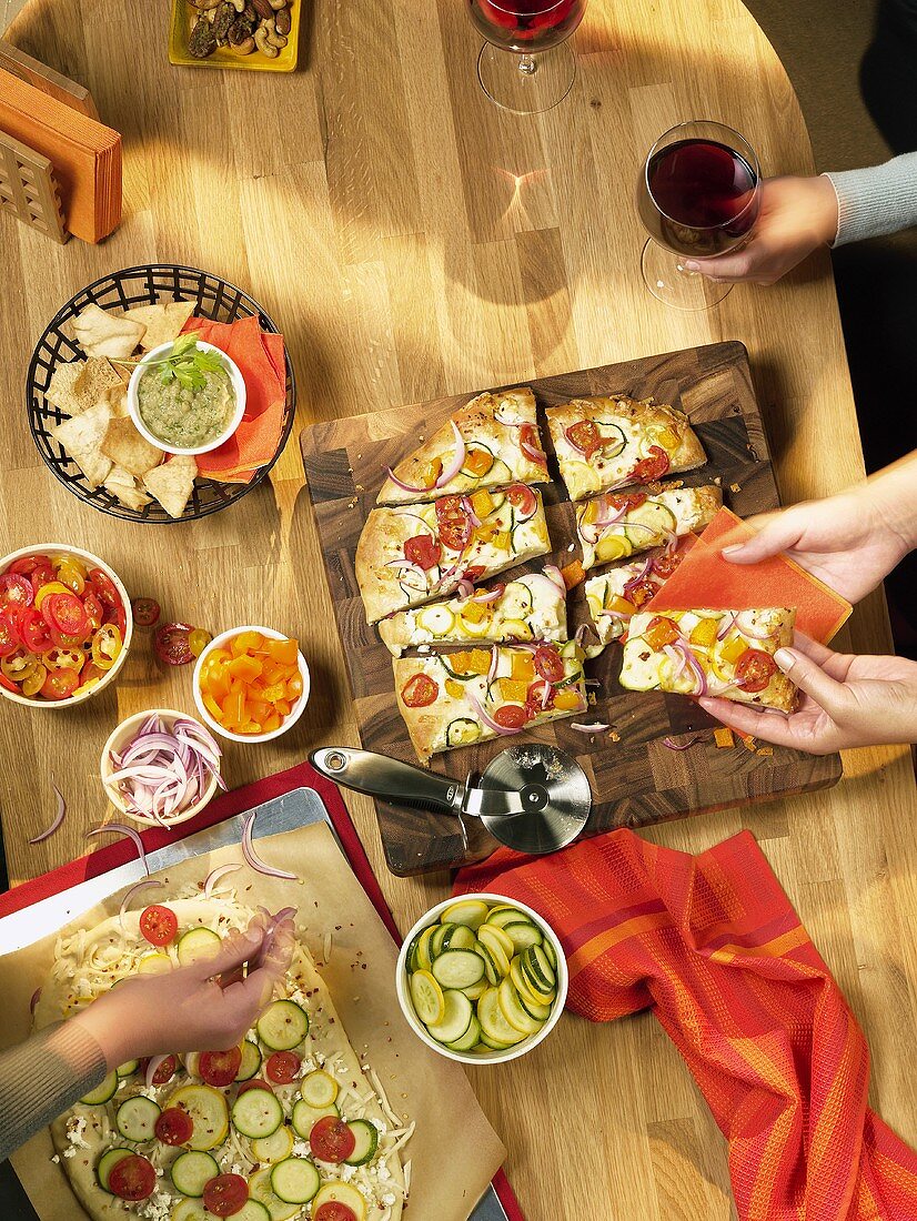 Pizza Party; People Making Pizza and Serving Cooked Pizza