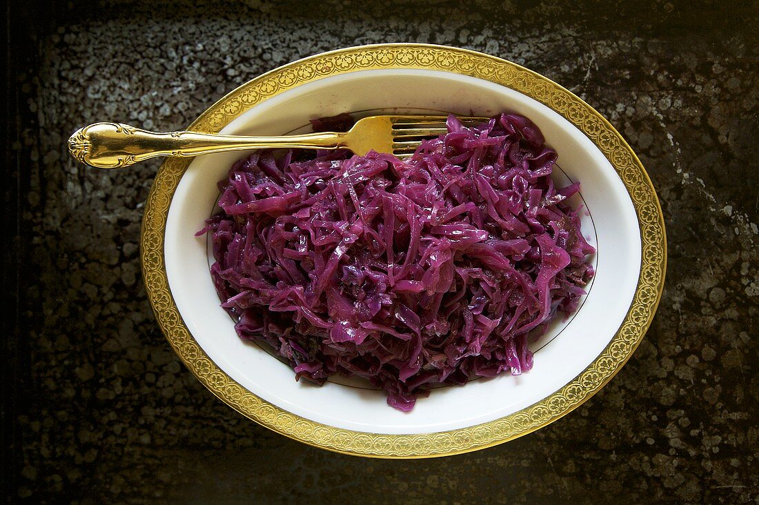 Geschmorter Rotkohl auf einer Platte mit goldener Gabel