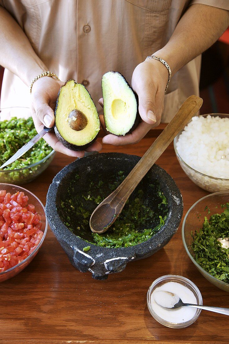 Man Holding Halved Avocado; Guacamole Ingredients