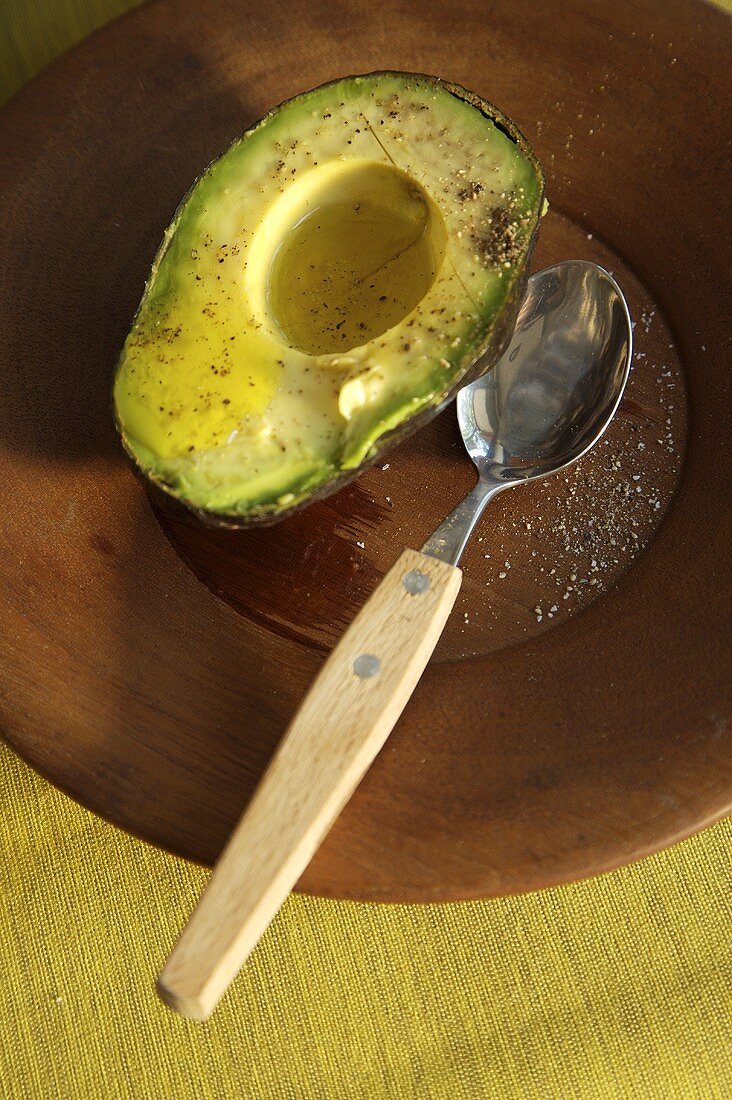 Avocado-Hälfte mit Vinaigrette und schwarzem Pfeffer