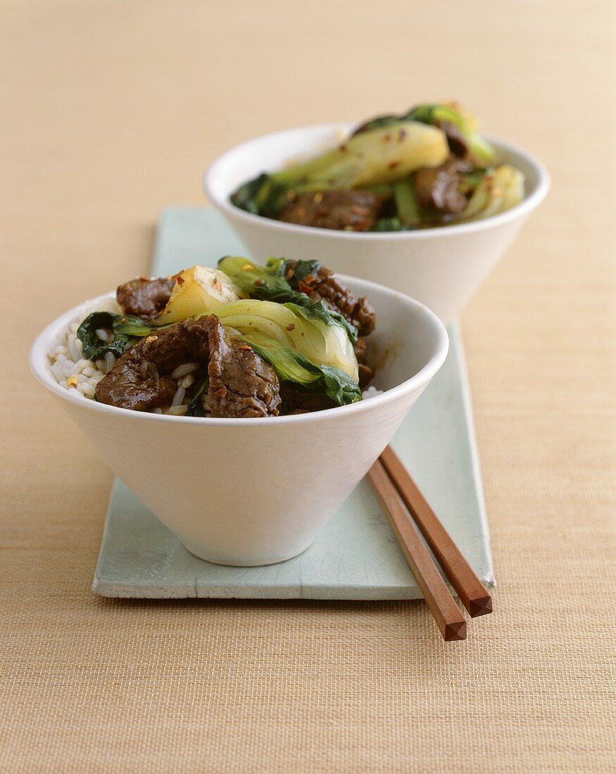 Bowls of Beef and Bok Choy Stir Fry Over Rice with Chopsticks