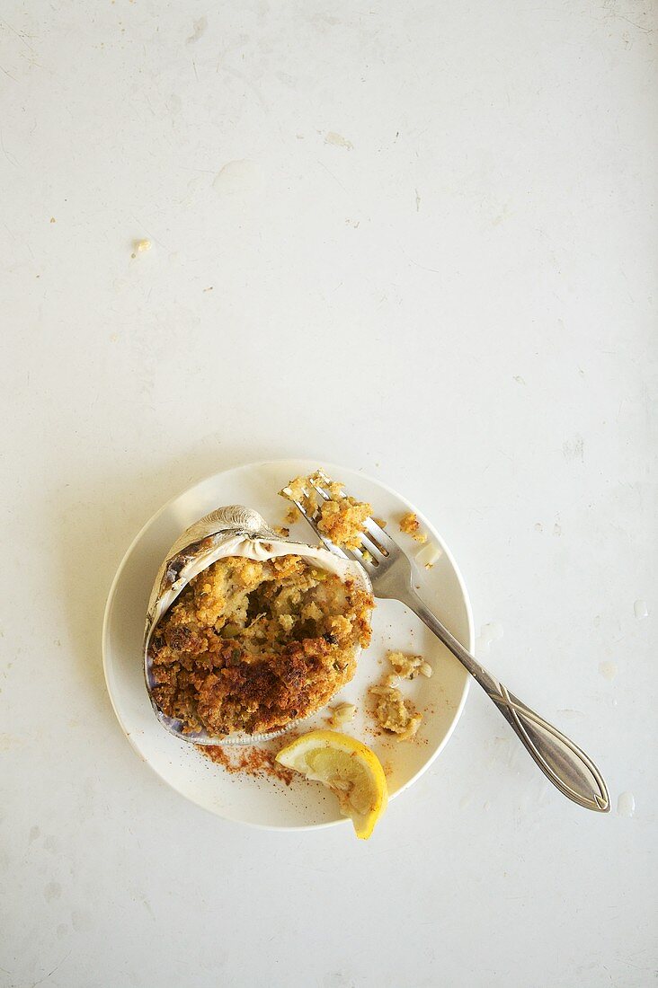 Überbackene Quahog-Muschel mit Zitronenecke auf einem Teller