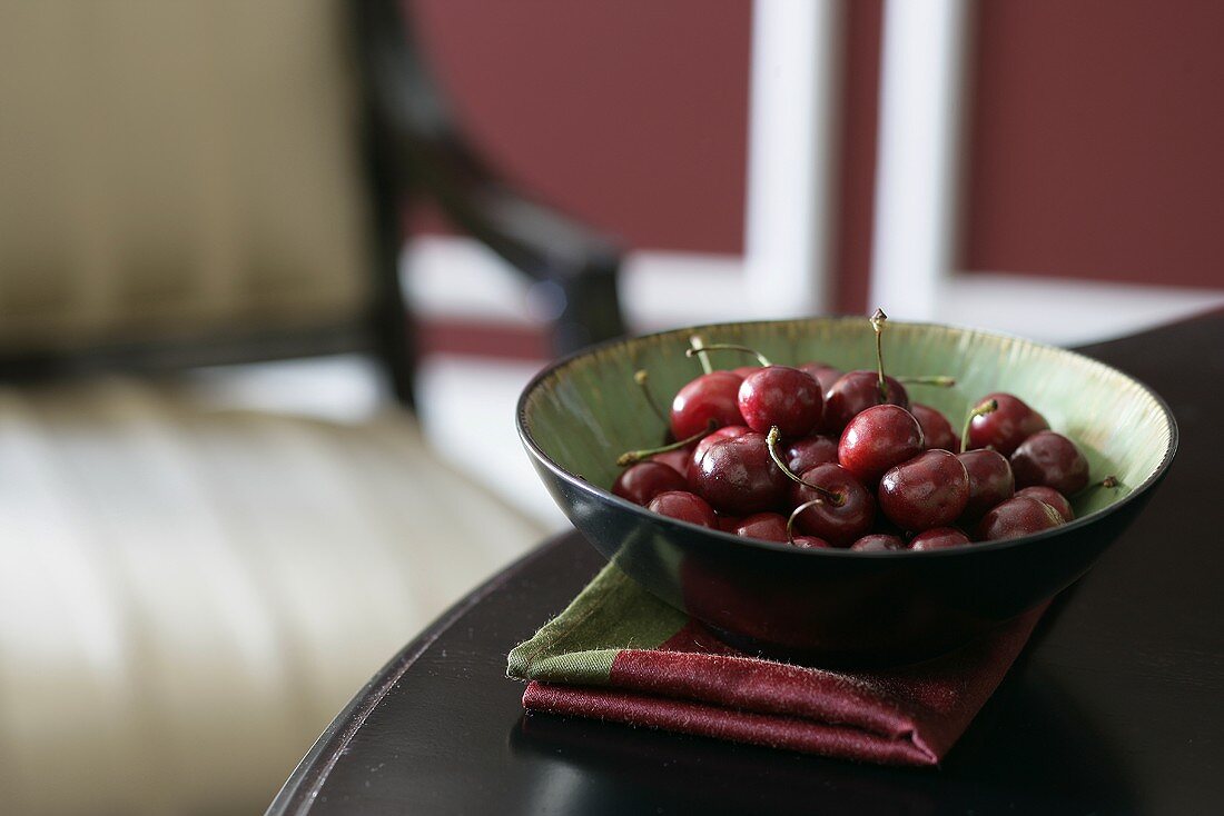 Bowl of Cherries on the Edge of a Table