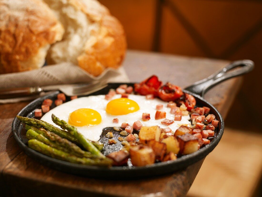 Breakfast Skillet with Fried Eggs, Diced Ham, Potatoes and Asparagus