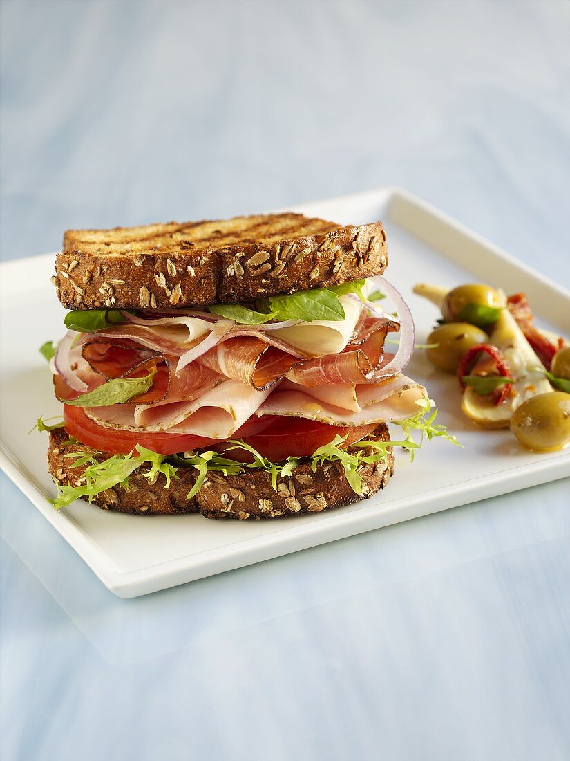 Sandwich mit Parma- und Putenschinken, Salat und Tomaten