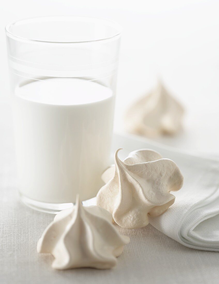 Two Meringue Cookies with a Glass of Milk