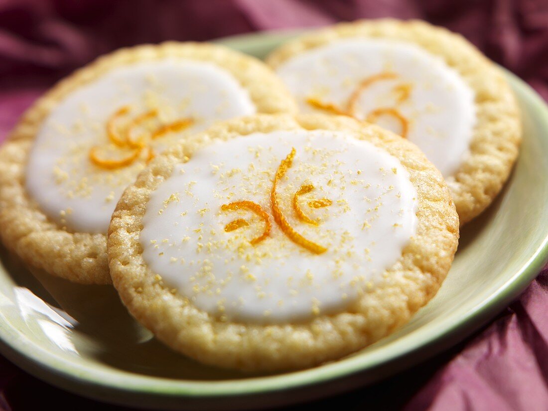 Drei Zitronenplätzchen mit Orangenzesten