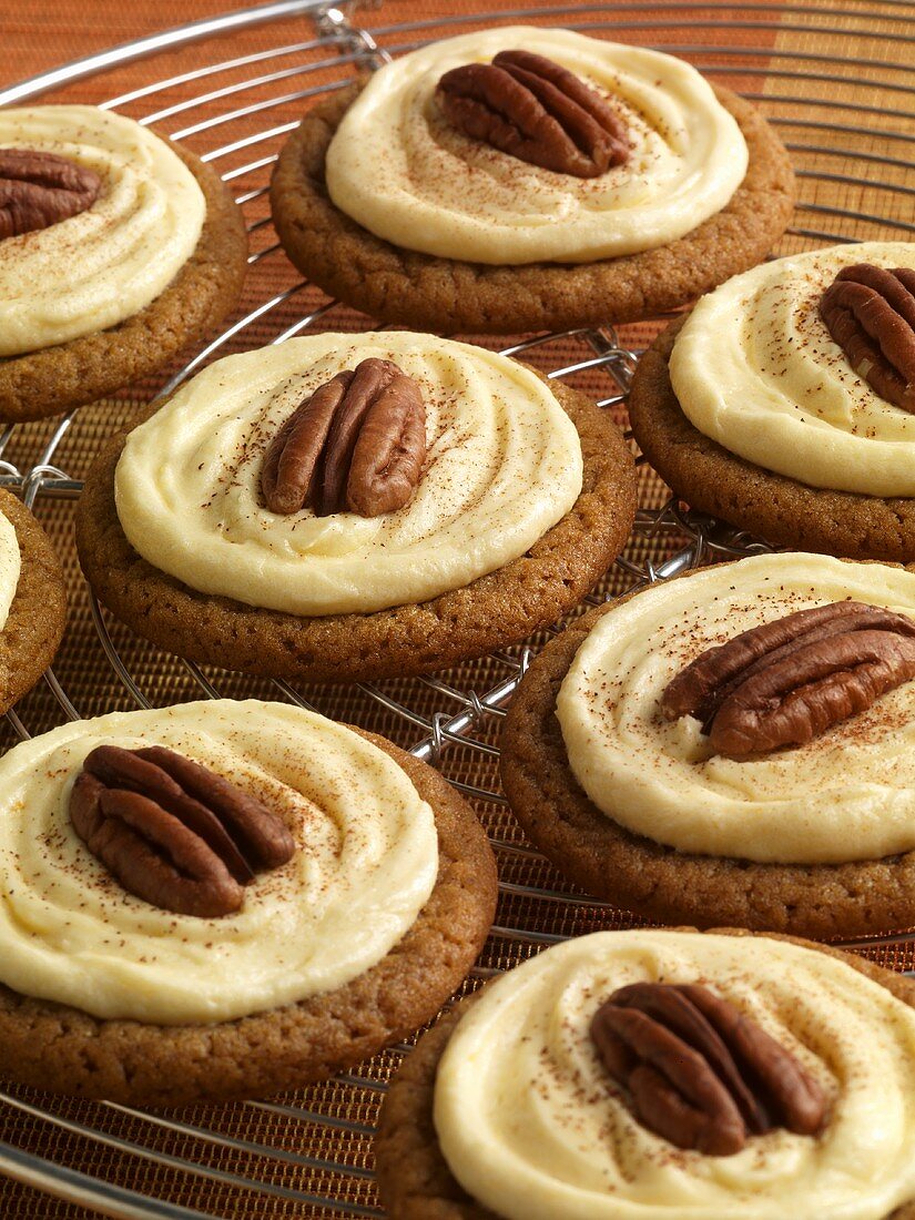 Ingwerplätzchen mit Creme und Pecannüssen auf Kuchengitter