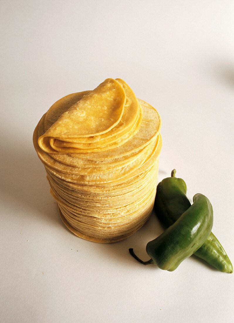 Ein Stapel Mais-Tortillas und zwei Jalapeno-Schoten