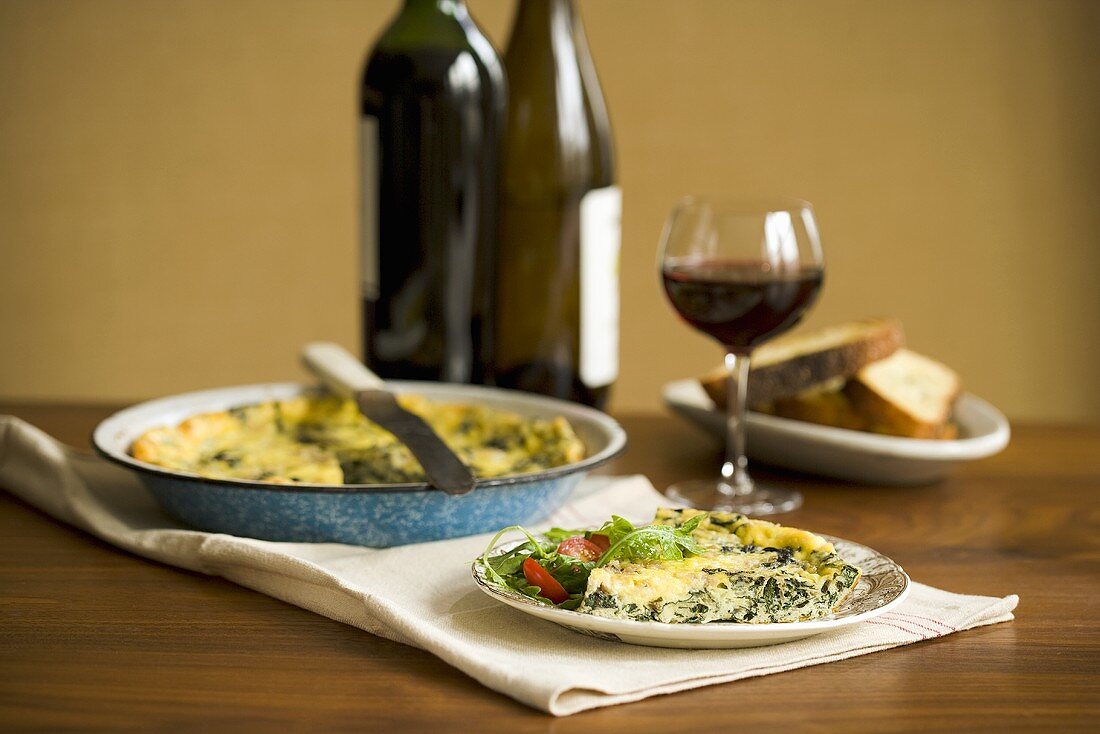 Slice of Vegetable Quiche on a Plate; With Red Wine
