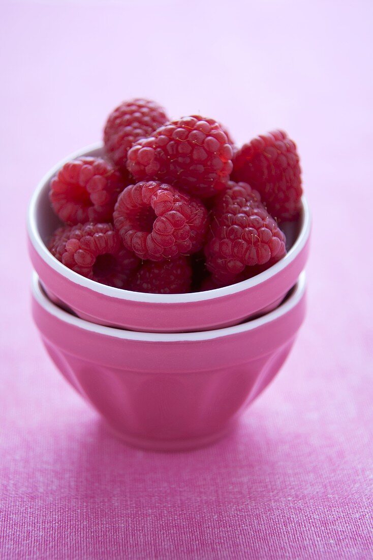 Rosa Schälchen mit frischen Himbeeren