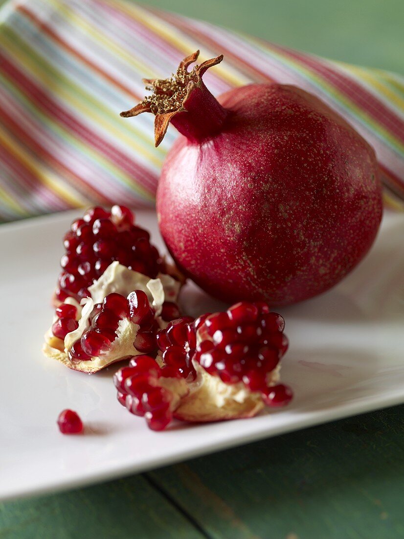 Ganzer Granatapfel und Granatapfelstücke