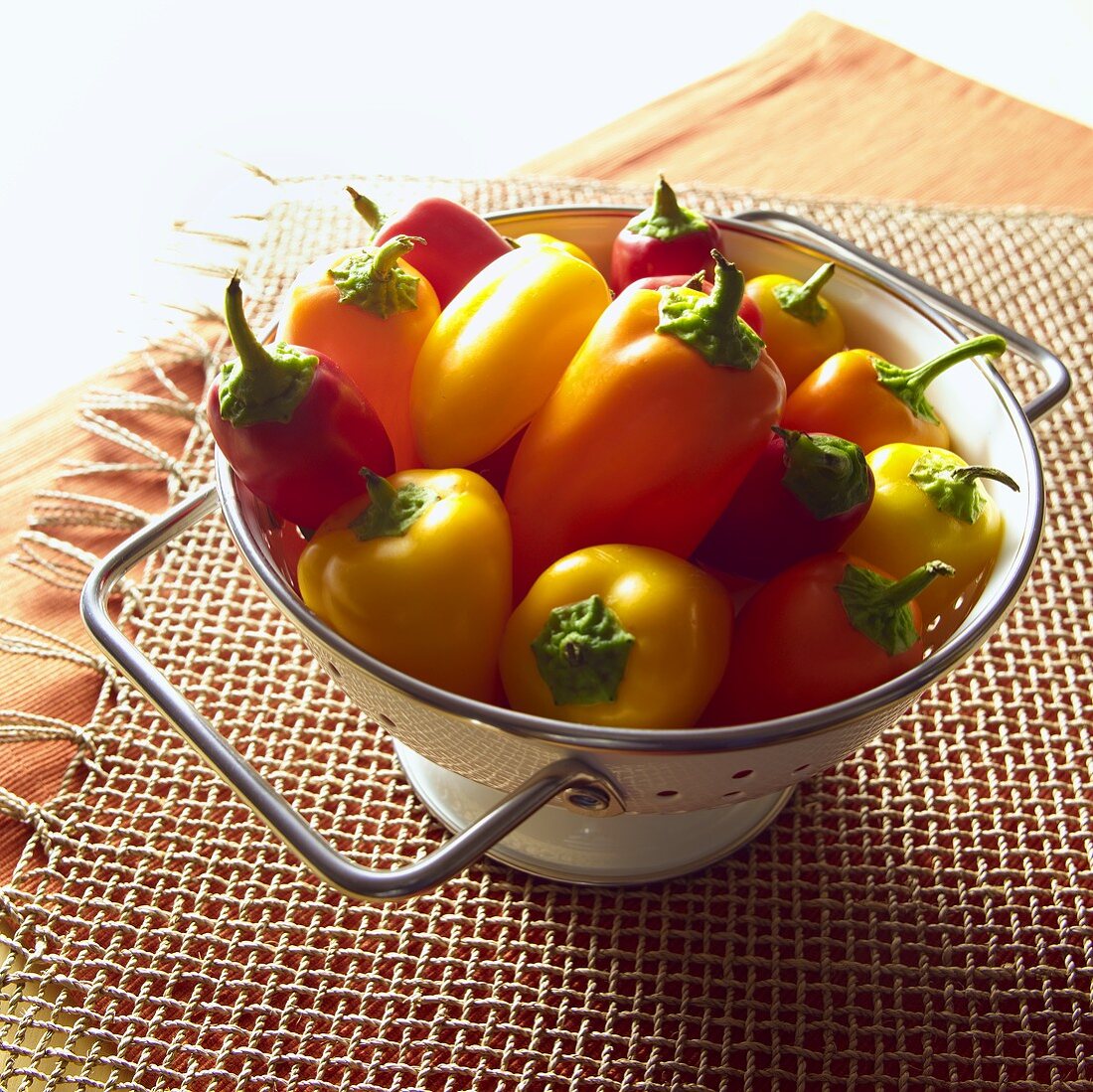 Red, Yellow and Orange Peppers in Colander