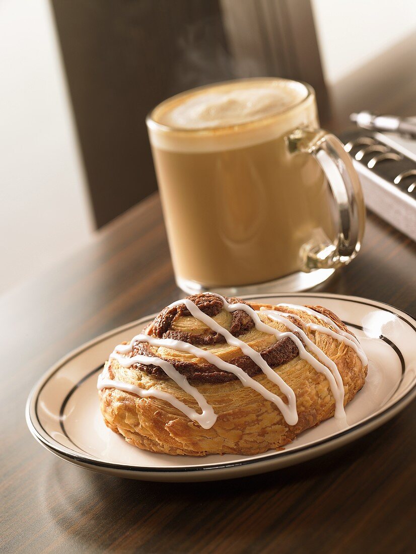 Cinnamon Bun with Icing; Cappuccino