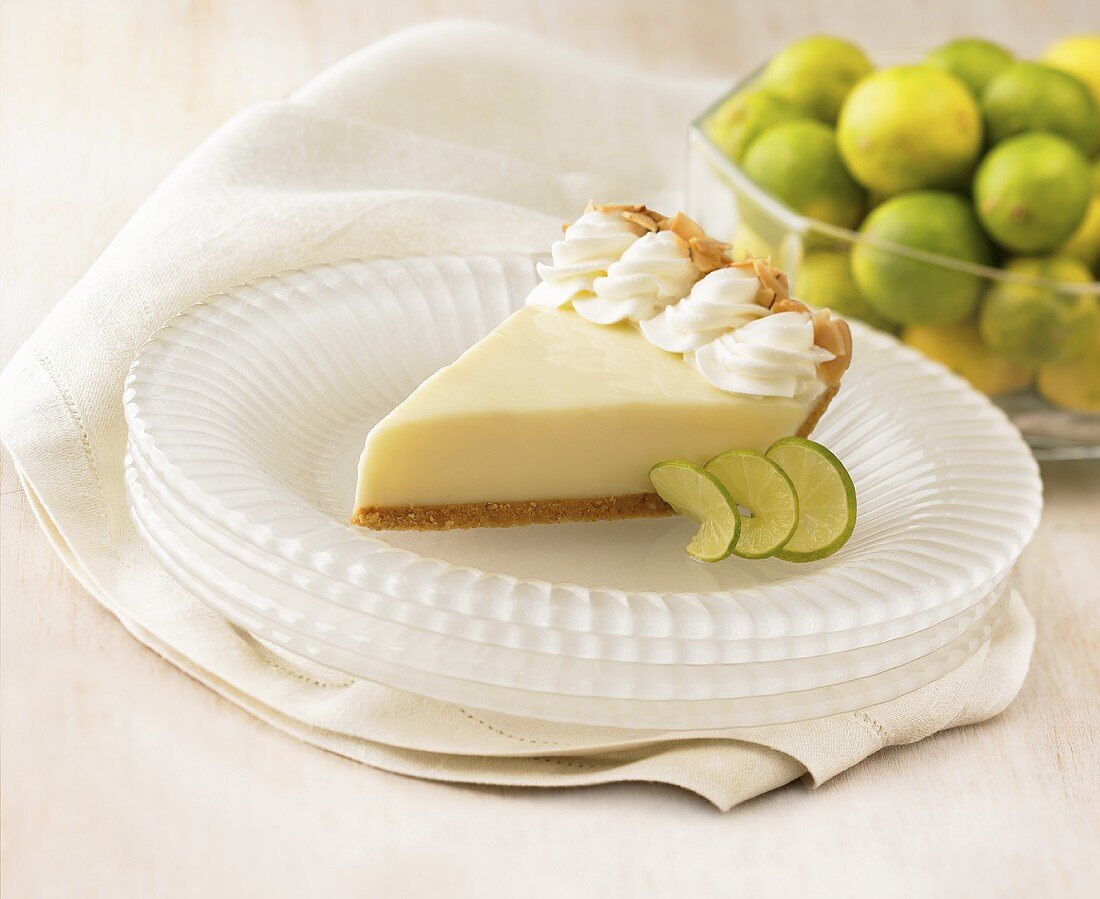 Stück Key Lime Pie, im Hintergrund Limetten