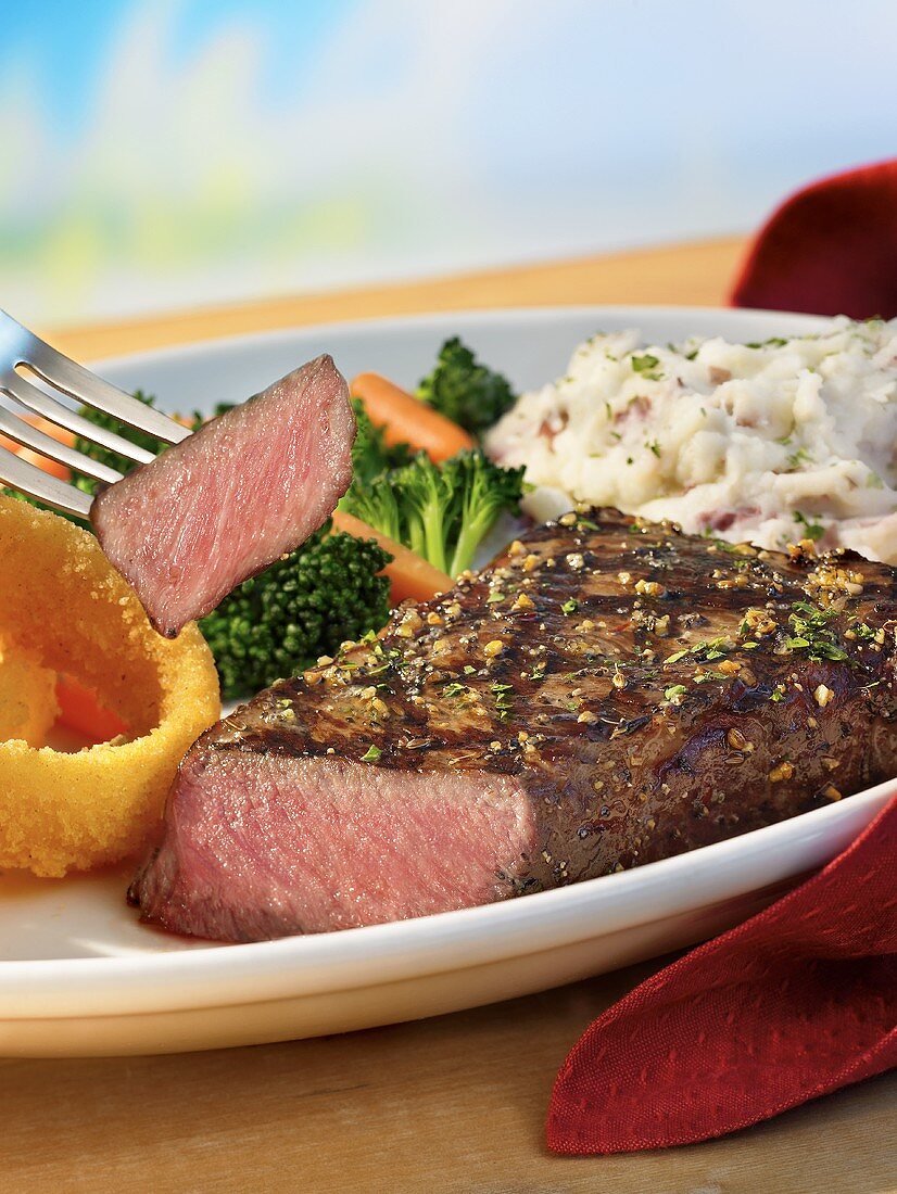 Piece of Strip Steak on Fork; Steak Dinner