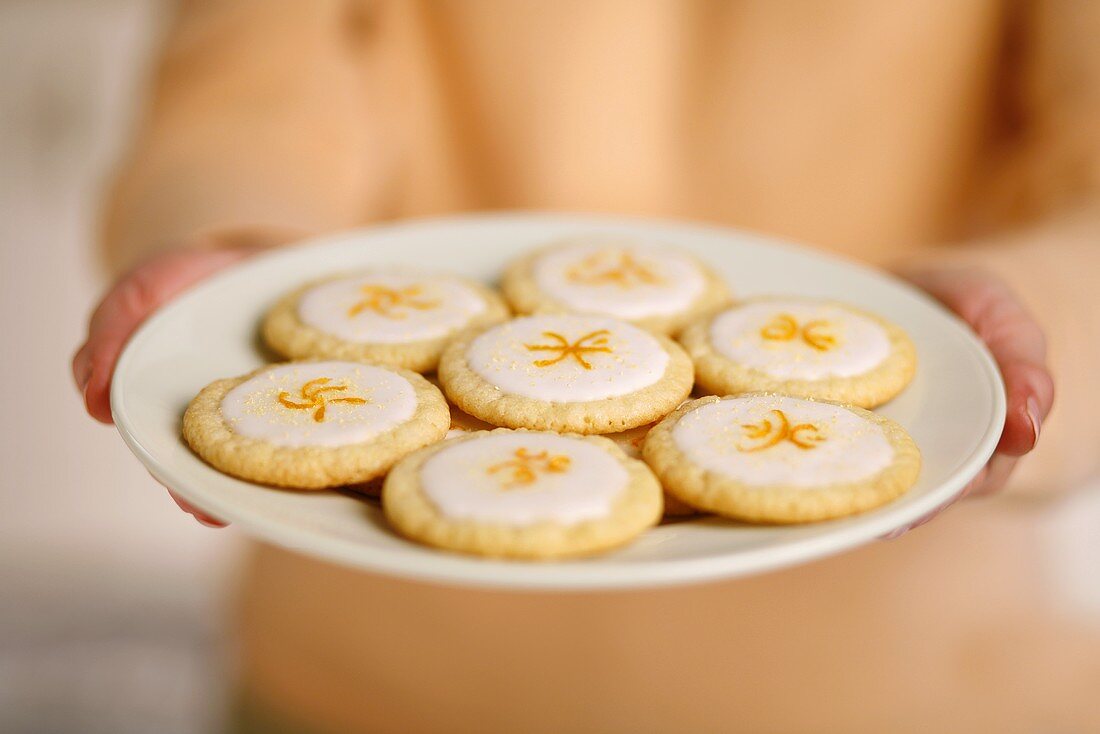 Woman Holding Plate of Lemon Cookies with Orange Zest