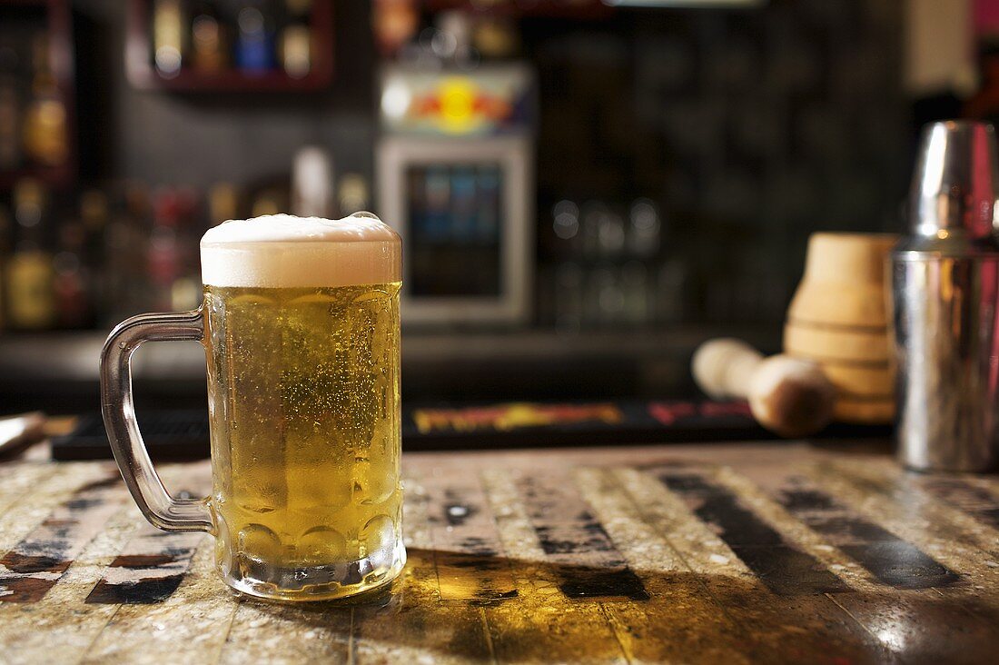 Glass of Beer with Foam on Bar Counter